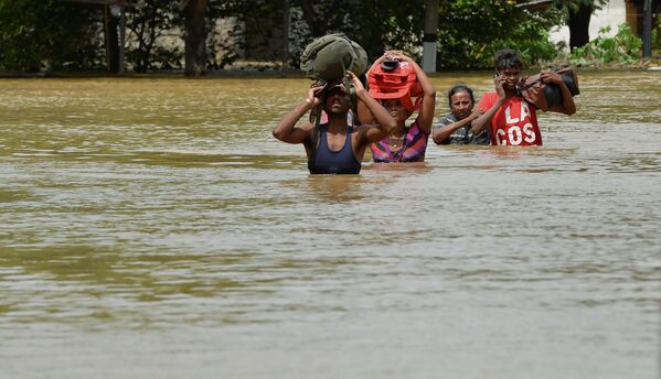 Жители Шри-Ланки пробираются через затопленные улицы деревни Кадувела - Sputnik Грузия