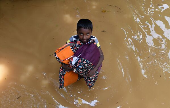 Мальчик пытается спасти часть имущества от наводнения в деревне Келаниа, Шри-Ланка - Sputnik Грузия