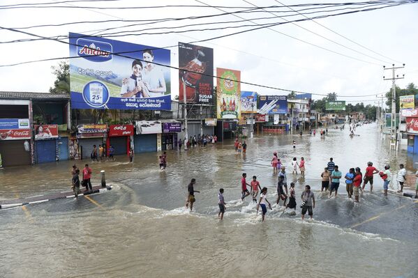 Жители Шри-Ланки пробираются через затопленные улицы в поселке Рагама - Sputnik Грузия