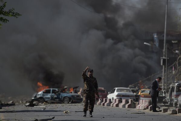 Так выглядело место теракта вскоре после взрыва. На фото - представитель службы безопасности на месте взрыва заминированной грузовой автомашины в Кабуле, Афганистан - Sputnik Грузия