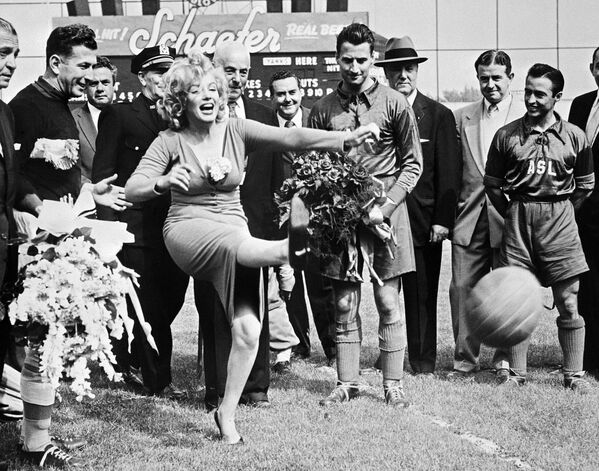 Американская актриса Мэрилин Монро бьет по мячу перед началом матча футбольного израильского клуба Хапоэль против команды всех звезд сборной США, Нью-Йорк, 16 мая 1957 года - Sputnik Грузия