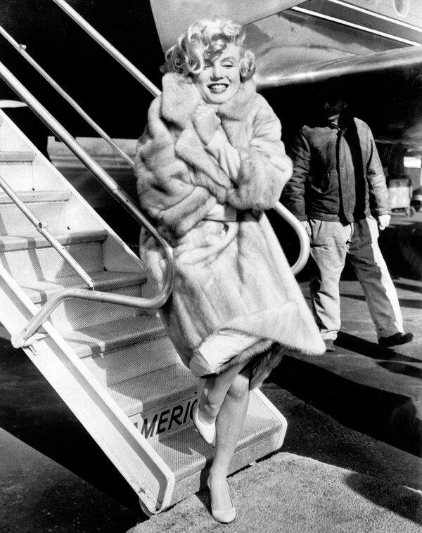 Американская актриса Мэрилин Монро позирует фотографам в аэропорту Ла Гардиа в 1959 году, прежде чем лететь в Чикаго на презентацию фильма В джазе только девушки - Sputnik Грузия