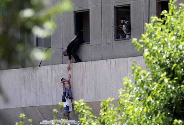 Мальчика эвакуируют во время нападения на иранский парламент в центральном Тегеране, Иран - Sputnik Грузия