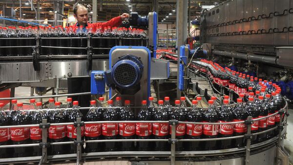 Сотрудник завода Coca-Cola работает на линии розлива продукции в пластиковую тару - Sputnik Грузия