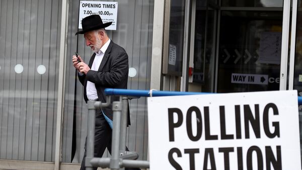Человек выходит из избирательного участка в Лондоне, Великобритания - Sputnik Грузия