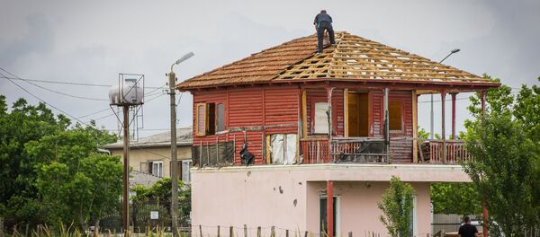 Мужчина на крыше своего дома в Анаклии - Sputnik Грузия