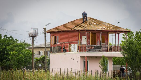 Мужчина на крыше своего дома в Анаклии - Sputnik Грузия