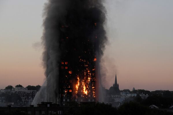 Клубы дыма поднимаются над горящим высотным жилым домом на Латимер-роуд в Лондоне. В результате пожара 24-х этажное жилое здание было полностью уничтожено огнем - Sputnik Грузия