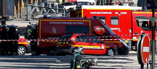 Пожарные осматривают тело подозреваемого, который лежит на земле на месте, где автомобиль протаранил автомобиль жандармерии на Елисейских полях в Париже, Франция - Sputnik Грузия