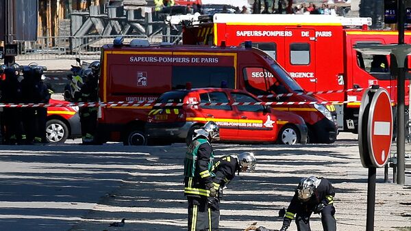 Пожарные осматривают тело подозреваемого, который лежит на земле на месте, где автомобиль протаранил автомобиль жандармерии на Елисейских полях в Париже, Франция - Sputnik Грузия