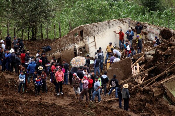 Жители стоят у дома, поврежденного оползнем в Сан-Педро-Соломе, Гватемала - Sputnik Грузия