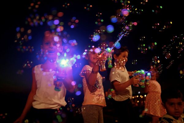Дети играют с мыльными пузырями на берегу Средиземного моря во время мусульманского праздника Ид аль-Фитр в Тель-Авиве, Израиль - Sputnik Грузия