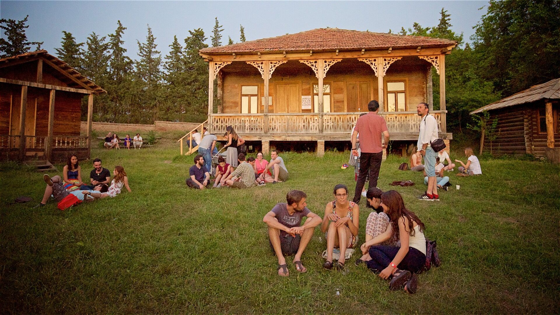 Люди отдыхают, сидя на земле на территории Этнографического музея летним вечером в Тбилиси - Sputnik Грузия, 1920, 20.05.2022