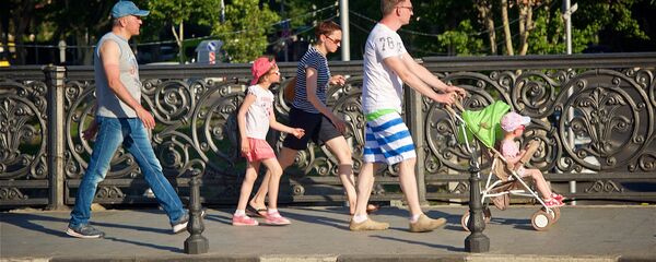 Семья туристов с детьми гуляет по центру Тбилиси - на фото они идут по Метехскому мосту - Sputnik Грузия