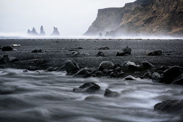 Черный пляж Рейнисфияра в Исландии – место весьма интересное. Он состоит из черного гравия и черных валунов. По легенде, на самом деле эти валуны были троллями, которые не успели спрятаться от солнечных лучей и окаменели - Sputnik Грузия
