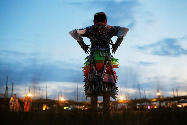 Девятилетняя Анхинга Бенални, спортсменка-юниорка из Навахо, готовится танцевать в первую ночь 32-го ежегодного Таос-Пуэбло-Пау-Вау, конкурса танцев коренных американцев, в Нью-Мексико, США - Sputnik Грузия