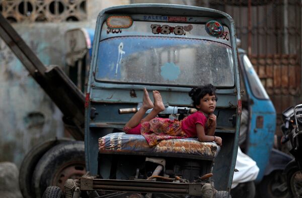 Девушка отдыхает на авторикше, припаркованном на улице в Карачи, Пакистан - Sputnik Грузия