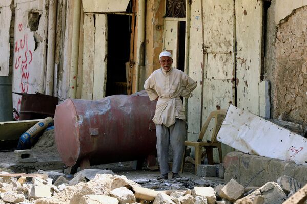 Человек у своего дома, разрушенного в ходе боевых действий в старом городе в Мосуле, Ирак - Sputnik Грузия