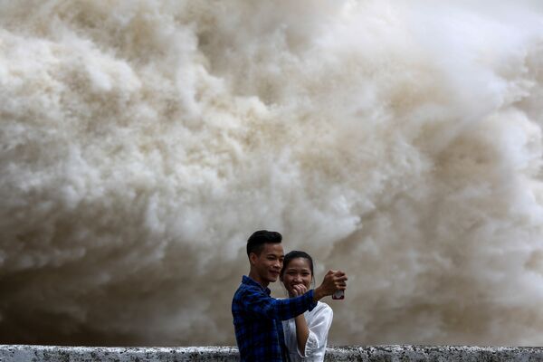 Пара делает селфи у гидроэлектростанции Хоа Бинь, которая открыла потолочные ворота после сильного ливня, вызванного тайфуном Талас, Вьетнам - Sputnik Грузия