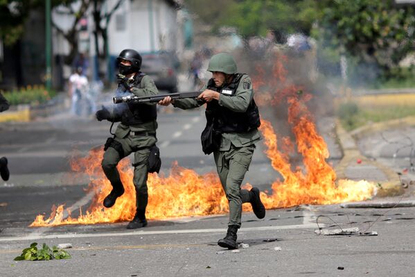 Сотрудники сил безопасности участвуют в наведении порядка во время митинга  против правительства президента Венесуэлы Николаса Мадуро в Каракасе, Венесуэла - Sputnik Грузия
