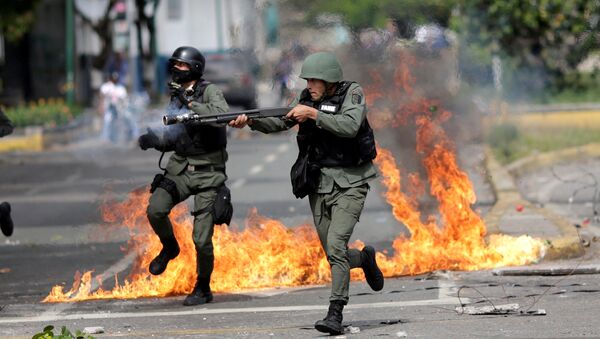 Сотрудник сил безопасности на митинге во время забастовки против правительства президента Венесуэлы Николаса Мадуро в Каракасе, Венесуэла - Sputnik Грузия