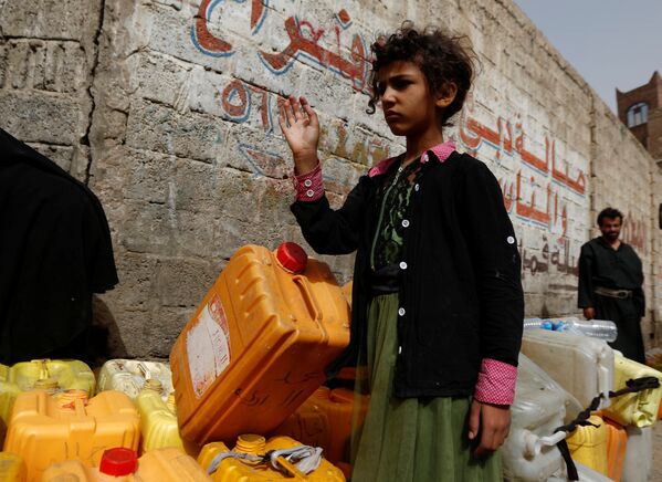 Девушка стоит с канистрами в очереди на улице, где из грузовика-танкера жителям предоставляют бесплатную питьевую воду во время вспышки холеры в Сане, Йемен - Sputnik Грузия