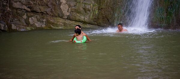 Семья купается в водопаде в летнюю жару в тбилисском Ботаническом саду Семья купается в водопаде в летнюю жару в тбилисском Ботаническом саду - Sputnik Грузия