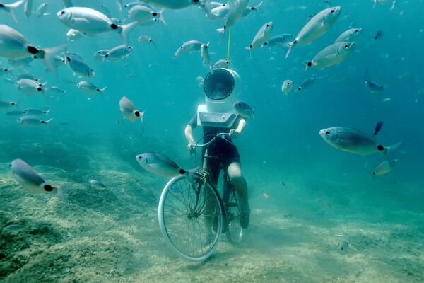 Женщина-дайвер делает вид, что катается на велосипеде на дне Подводного парка в Пуле, Хорватия. В последние дни в ряде стран Европы установилась аномально жаркая погода - Sputnik Грузия