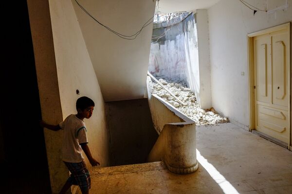 Мальчик из семьи сирийских беженцев в одном из домов в городе Хальба на севере Ливана, 2013 год - Sputnik Грузия