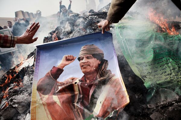 Жители Бенгази сжигают портреты Муамара Каддафи, плакаты с его цитатами и Зеленую книгу Каддафи, 2011 год - Sputnik Грузия