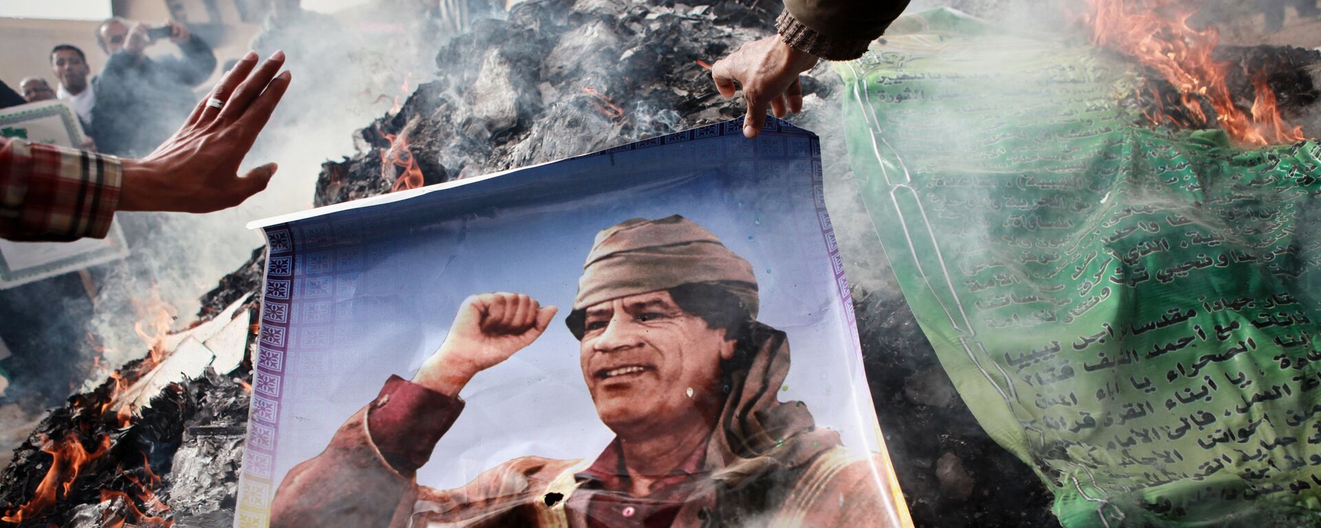 Жители Бенгази сжигают портреты Муамара Каддафи, плакаты с его цитатами и Зеленую книгу Каддафи, 2011 год - Sputnik Грузия, 1920, 04.02.2019