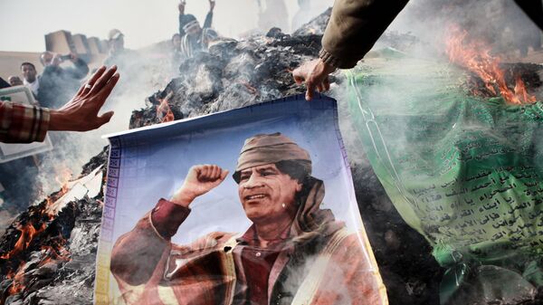 Жители Бенгази сжигают портреты Муамара Каддафи, плакаты с его цитатами и Зеленую книгу Каддафи, 2011 год - Sputnik Грузия