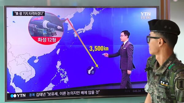 Южнокорейский солдат проходит мимо телевизионного экрана, где демонстрируется график расстояния между Северной Кореей и Гуамом, на железнодорожной станции в Сеуле - Sputnik Грузия
