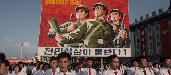Люди несут плакат во время митинга в поддержку позиции Северной Кореи против США на площади Ким Ир Сена в Пхеньяне Люди несут плакат во время митинга в поддержку позиции Северной Кореи против США на площади Ким Ир Сена в Пхеньяне - Sputnik Грузия