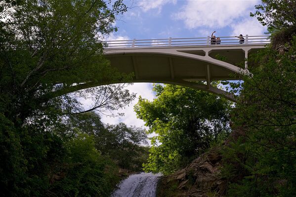 Через речку Цавкисисцкали на территории ботанического сада перекинуты три моста. На фото - туристы фотографируют с моста один из водопадов в тбилисском Ботаническом саду - Sputnik Грузия