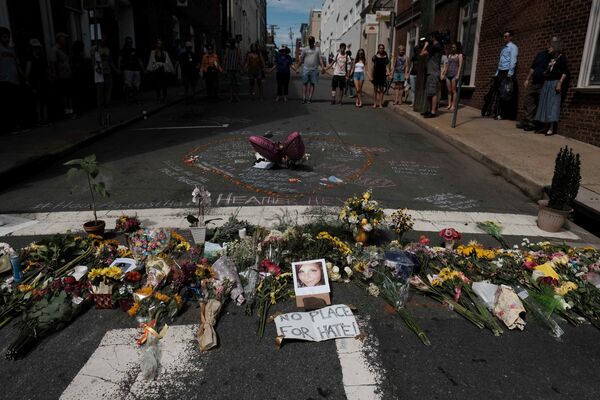 Цветы в память о погибшей в результате наезда автомобиля на людей в Шарлоттсвилле Хизер Хейер и ее фотография на временном мемориале в Шарлоттсвилле - Sputnik Грузия