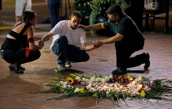 Люди пытаются успокоить Джозефа Калвера (в центре), когда он встает на колени, чтобы выразить свое уважение другу, пострадавшему в результате наезда автомобиля - Sputnik Грузия