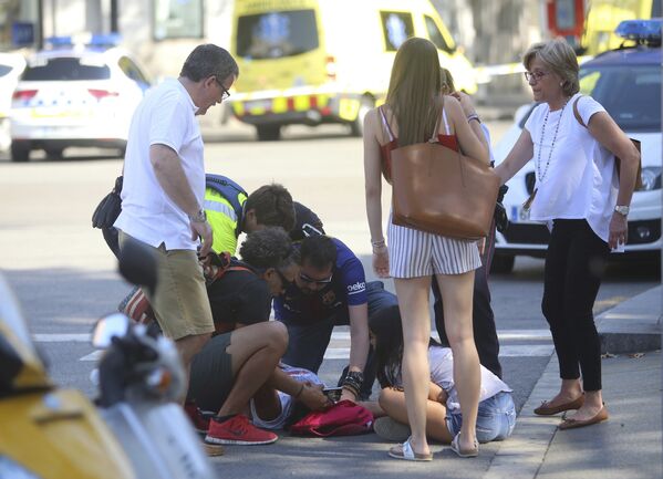 Люди помогают пострадавшему в результате теракта в Барселоне, где минивэн наехал на скопление людей - Sputnik Грузия