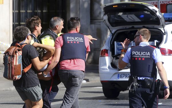 Полицейские и спасатели уносят пострадавшего с места наезда на людей в центре Барселоны - Sputnik Грузия
