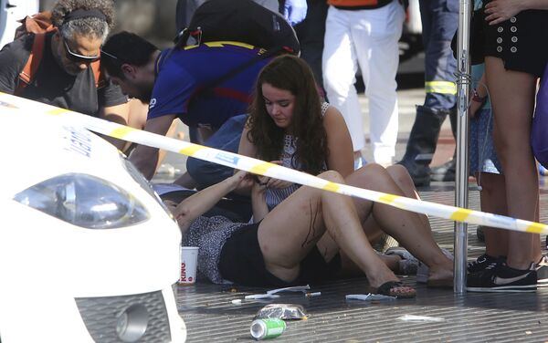 Прохожие и спасатели оказывают первую помощь пострадавшим в результате теракта в Барселоне, где минивэн наехал на скопление людей в центре города - Sputnik Грузия