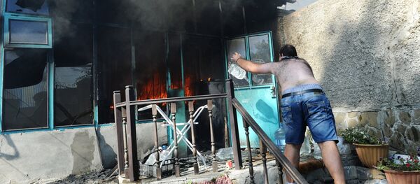 Мужчина тушит пожар в жилом секторе Ростова-на-Дону - Sputnik Грузия