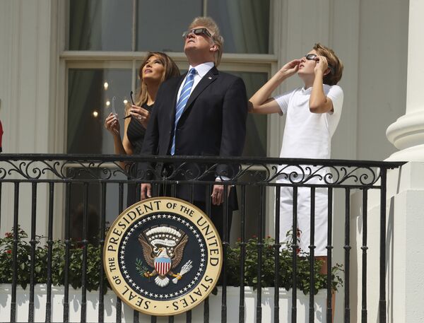 Президент Дональд Трамп, первая леди Мелания Трамп и их сын Бэррон наблюдают за солнечным затмением в Белом доме в Вашингтоне - Sputnik Грузия