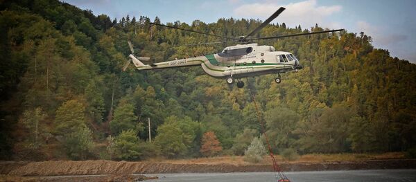 Вертолет Ми-8 МВД Грузии забирает воду в реке для тушения пожара в Боржоми-Харагаульском лесу - Sputnik Грузия