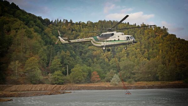 Вертолет Ми-8 МВД Грузии забирает воду в реке для тушения пожара в Боржоми-Харагаульском лесу - Sputnik Грузия