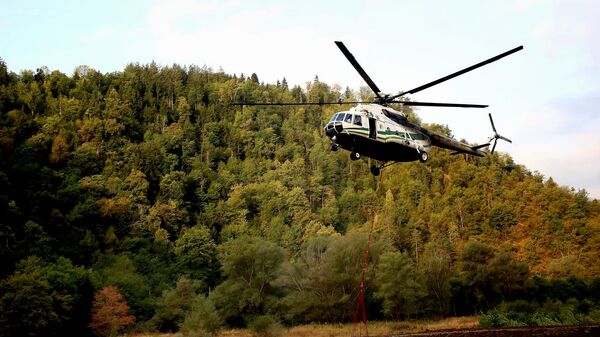 Вертолет Ми-8 МВД Грузии забирает воду в реке для тушения пожара в Боржоми-Харагаульском лесу - Sputnik Грузия