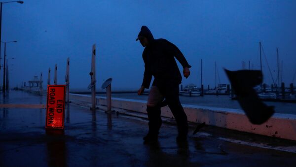 Мусор пролетает мимо человека, который пытается пройти под порывами ветра от урагана Харви в Корпус-Кристи, штат Техас, США - Sputnik Грузия