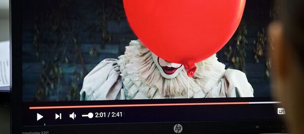 Девушка смотрит трейлер фильма Оно на экране компьютера - Sputnik Грузия