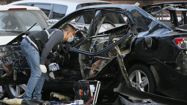 Эксперт рядом с машиной, пострадавшей от взрыва в Киеве - Sputnik Грузия