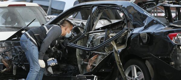 Эксперт рядом с машиной, пострадавшей от взрыва в Киеве - Sputnik Грузия