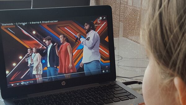 Девушка смотрит выпуск украинского X-Factor с участием грузинской группы Diamonds - Sputnik Грузия